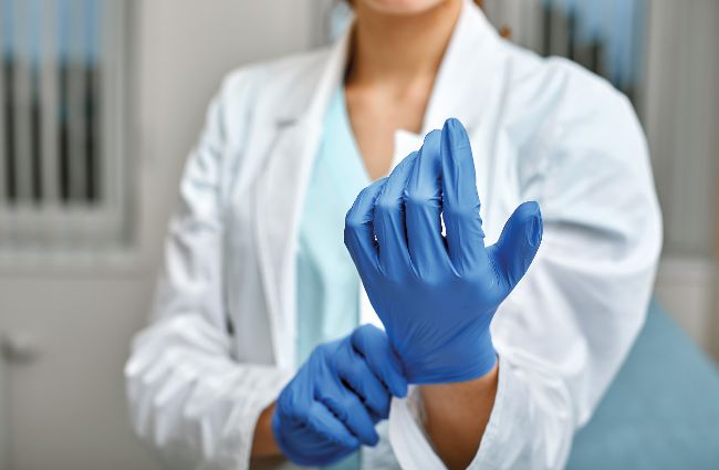 Practitioner putting on gloves